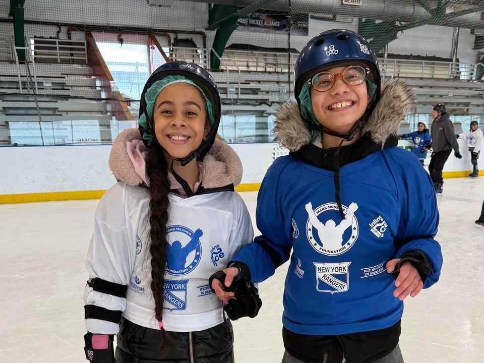 Two smiling North Park skaters on the ice